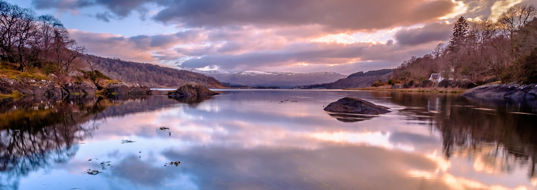 Loch Aline on a calm early spring evening with a mirror like surface reflecting the clouds pink colours of sunset | Morvern Scotland