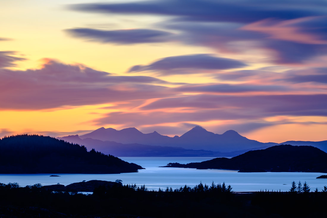 A distant view of Kentra Bay at sunset with the peaks of the Small Isle of Rùm beyond | Ardnamurchan Scotland | Steven Marshall Photography