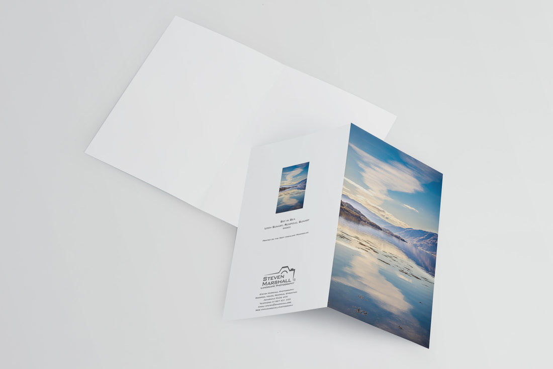 An A6 greeting card featuring a calm Loch Sunart at Resipole under a blue sky with white clouds that a reflected in its mirror like surface | Sunart Scotland