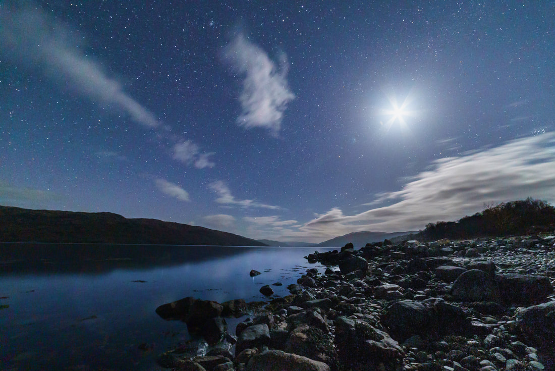 Rays of light bursting from the moon and lighting up the rocky shore of Loch Sunart | Sunart Scotland