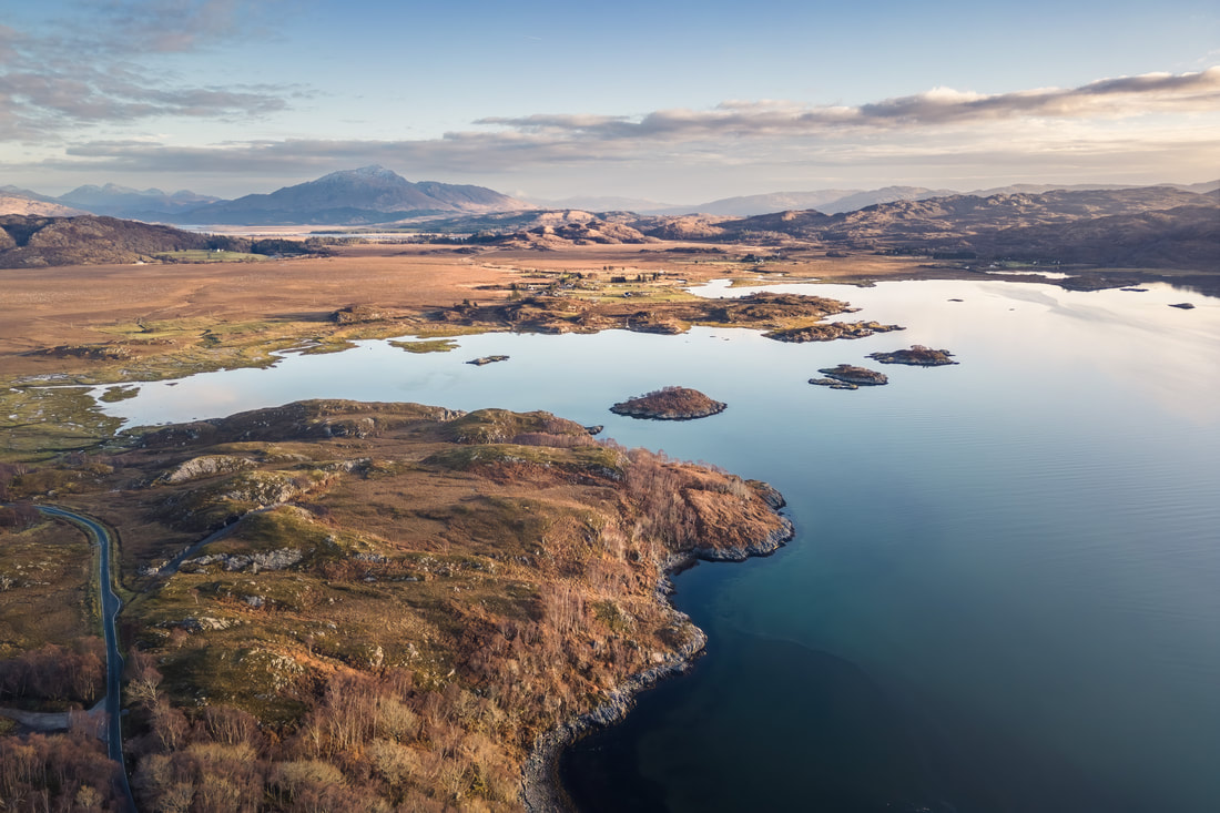 Aerial view of Kentra Bay with the low winter sun lighting Kentra crofting township and Ben Resipole in the distance | Ardnamurchan Scotland | Steven Marshall Photography