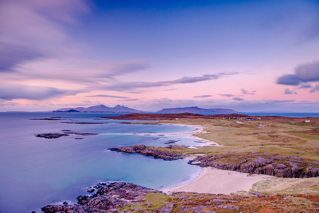 The view looking north over Sanna Bay to the Small Isles during an Autumn sunset with a pink tinged sky | Ardnamurchan Scotland