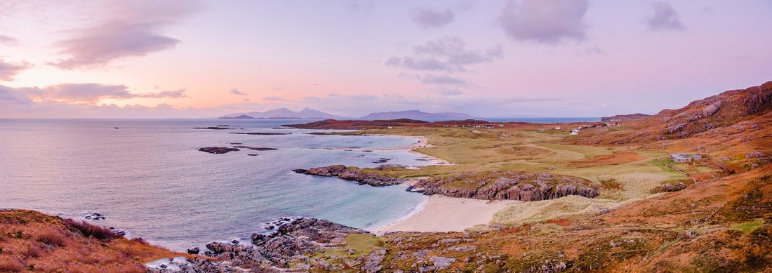 The view looking north over Sanna Bay to the Small Isles during an Autumn sunset with a pink tinged sky | Ardnamurchan Scotland
