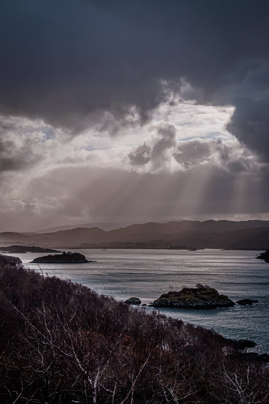 The view over Kentra Bay from Ardtoe In the aftermath of Storm Dennis with clearing clouds crepuscular rays to shine down onto the waters at its entrance | Ardnamurchan Scotland