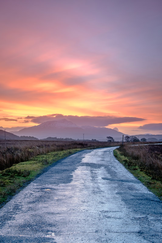 The road from Ardtoe to Kentra at sunrise with a colourful view of the sky beyond Ben Resipole | Ardnamurchan Scotland