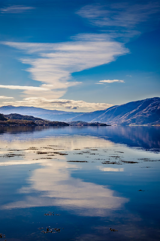 A long ribbon of cirrostratus cloud reflected on the surface of Loch Sunart on a calm Spring morning | Sunart Scotland
