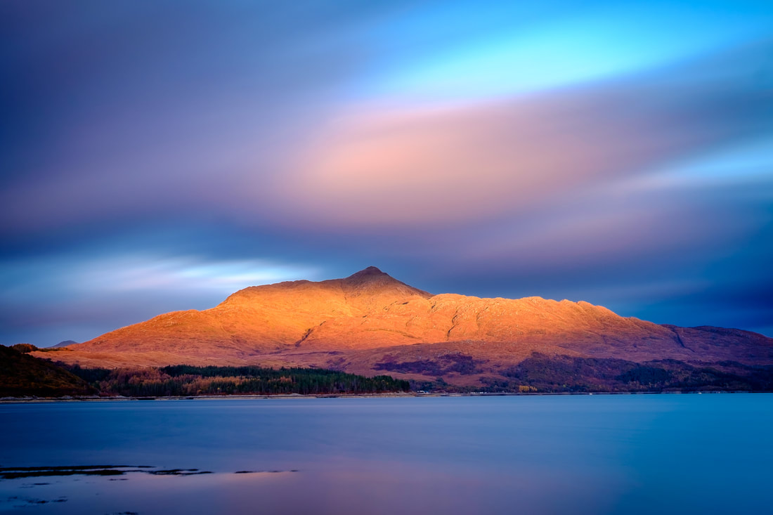 Light from a setting sun painting the slopes of Ben Resipole with shades of red and gold | Sunart Scotland