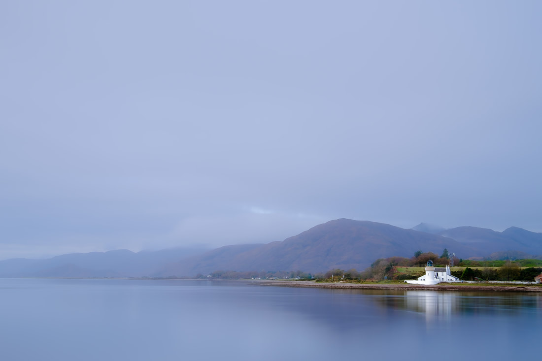 The Corran Lighthouse emerging from clearing morning mist and reflected in the calm waters of Loch Linnhe | Ardgour Scotland