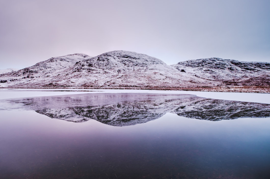 Meall a' Bhraghaid reflected in the partially frozen surface of Lochan Doire a' Bhraghaid | Ardgour Scotland