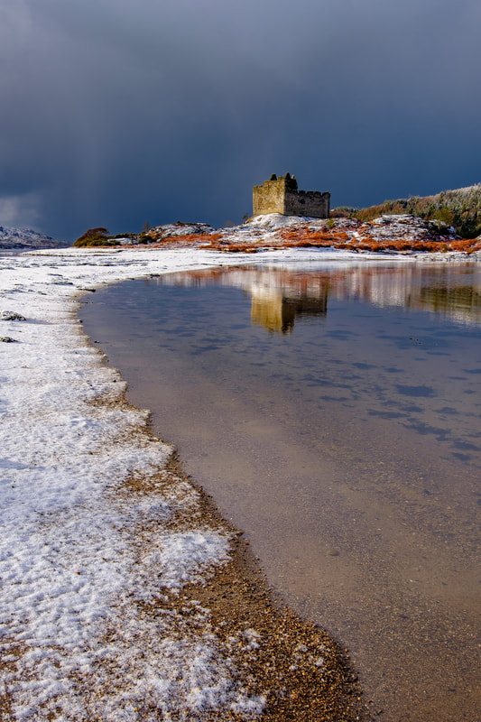 A fresh fall of snow at high tide meeting the sea on the sandbar causeway that leads across to Castle Tioram | Moidart Scotland
