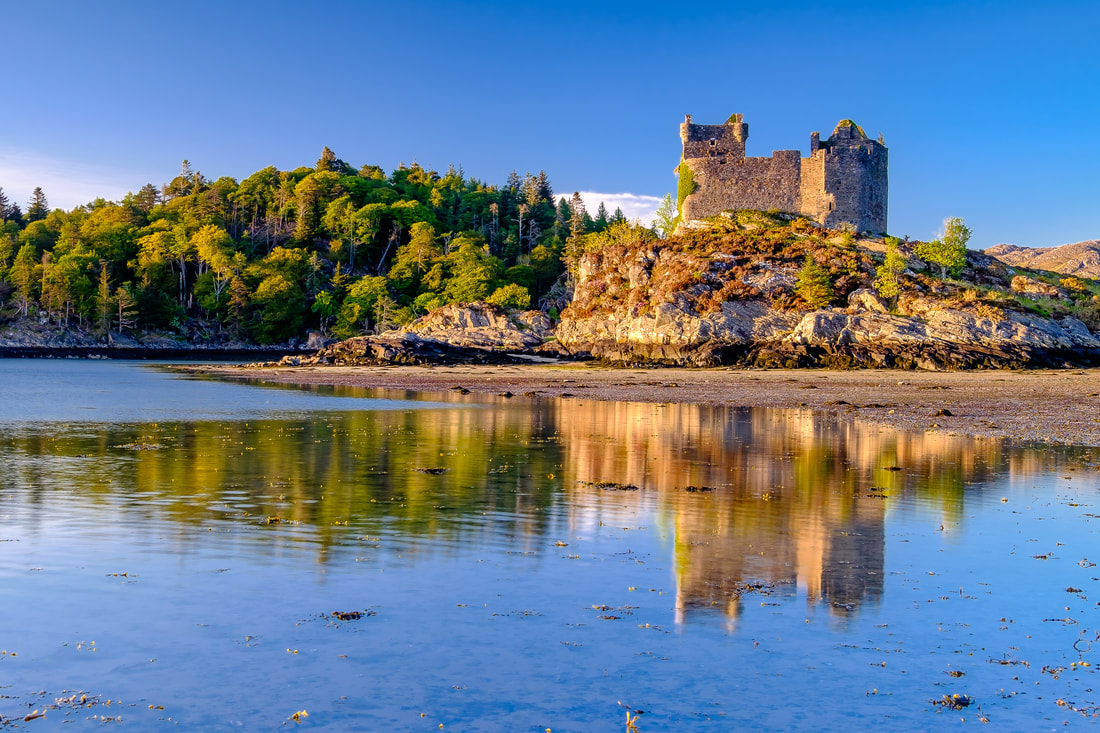 Low sun lighting up the western facing walls of Castle Tioram and the island upon which it sits | Moidart Scotland