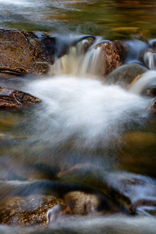 A close up of water flowing down through one of the many cascades of Resipole Burn | Sunart Scotland