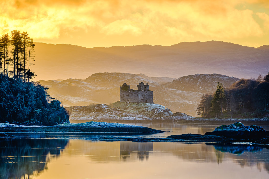 Castle Tioram viewed from across Loch Moidart looking through the gap in between Eilean an Fheidh and Eilean Shona and backlit by golden winter light | Moidart Scotland | Steven Marshall Photography