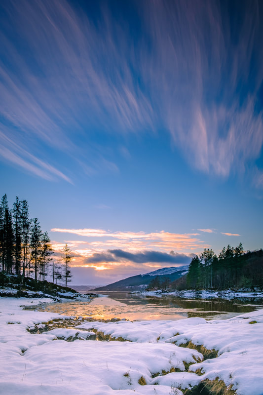 Wispy cirrus clouds high above a snow-covered Bay of Flies at sundown | Ardnamurchan Scotland
