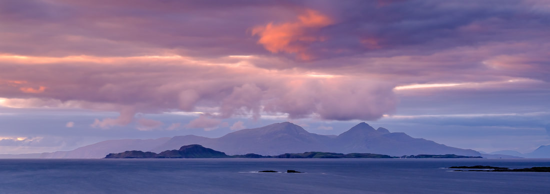 The pink clouds of dusk in the sky above the Small Isles of Rùm and Muck, viewed from Portuairk | Ardnamurchan Scotland