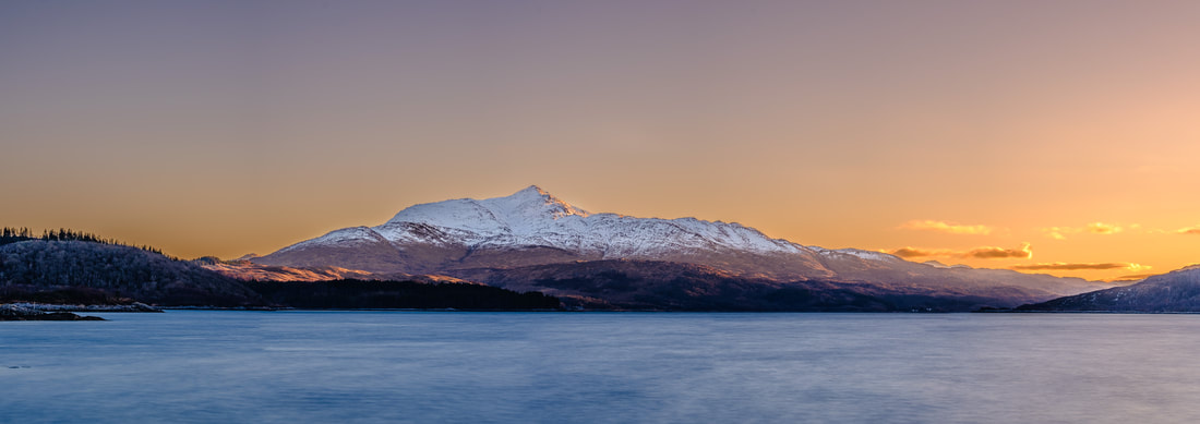 The first light of a winter’s day bathing the south facing upper slopes of a snow-capped Ben Resipole with warm golden light | Sunart Scotland