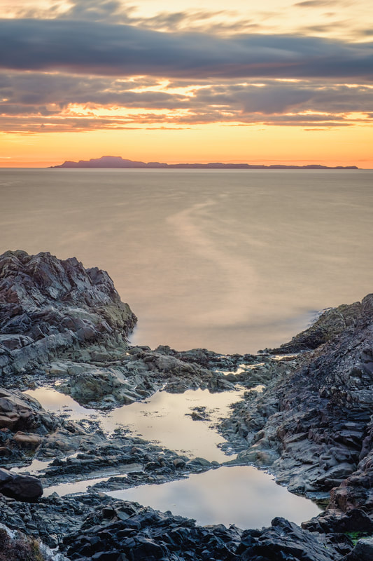 The Small Isle of Muck beneath an orange sunset sky at Fascadale | Ardnamurchan Scotland | Steven Marshall Photography