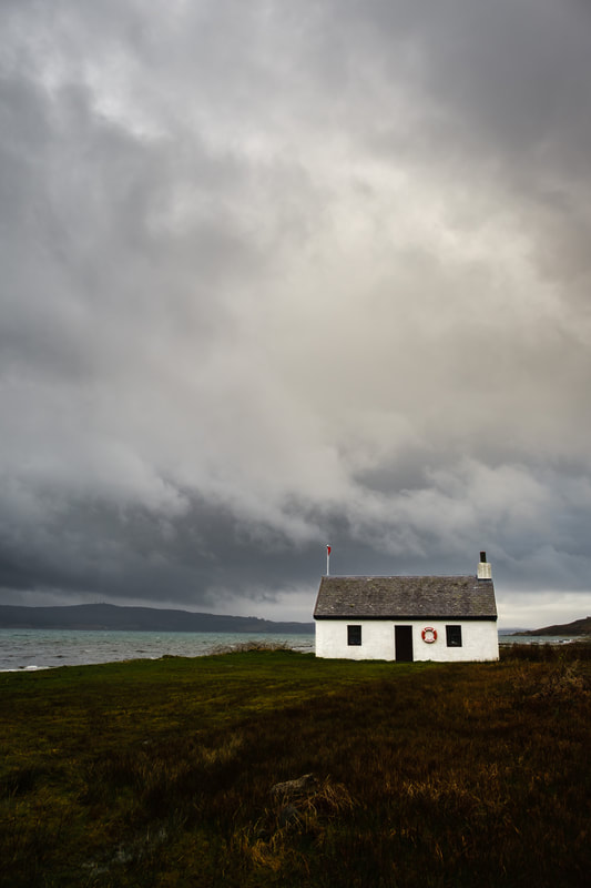 Photographic print of Shore Cottage at Kilchoan under a grey, storm laden sky. Image of Ardnamurchan on the West Highland Peninsulas, Scotland.