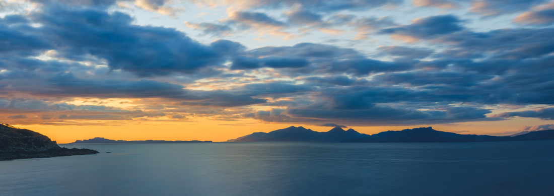 The Small Isles of Muck and Rum beneath a blue and orange sunset sky | Ardnamurchan Scotland | Steven Marshall Photography