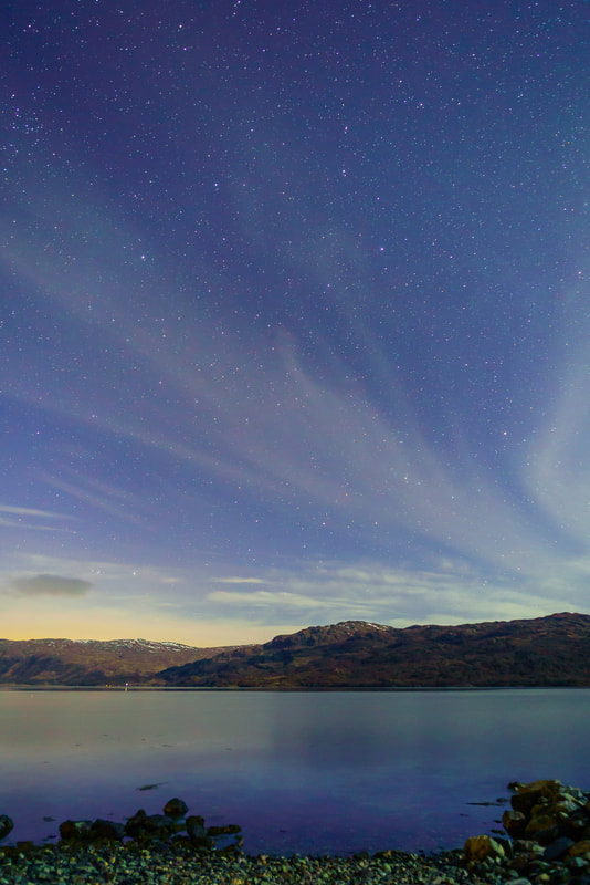 Thin, layered Cirrostratus high in the night sky over Loch Sunart and illuminated by the light from a first quarter moon | Sunart Scotland