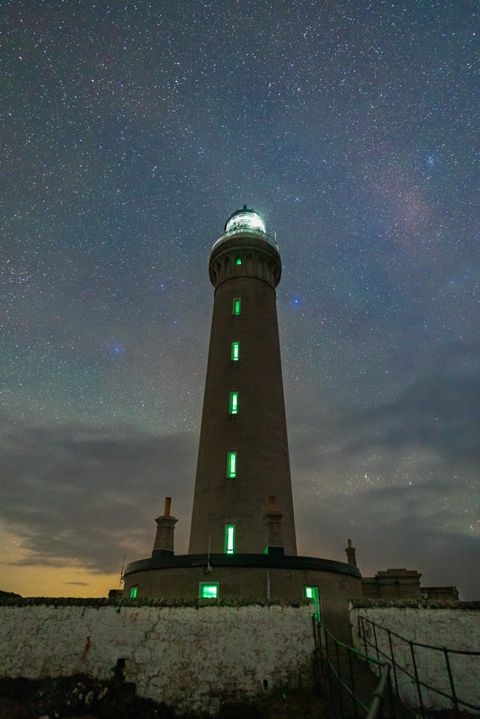 The light of Ardnamurchan Lighthouse shining bright under a starry night sky | Ardnamurchan Scotland
