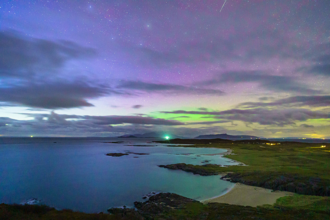 The view north over Sanna Bay on a starry night with Northern Lights in the sky above the Small Isles of Muck, Eigg and Rum | Ardnamurchan Scotland