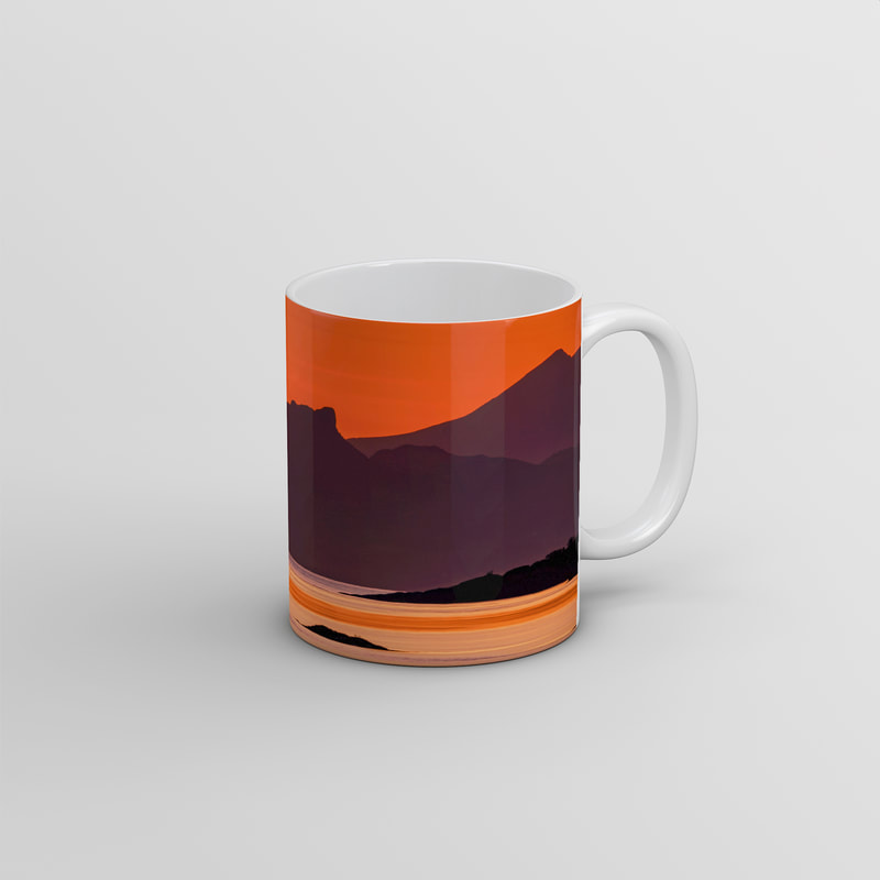 Souvenir photo mug featuring an image An Sgurr, the prominent peak on the Isle Eigg, viewed against an orange sunset sky through the gap at the entrance to Kentra Bay | Ardnamurchan Scotland